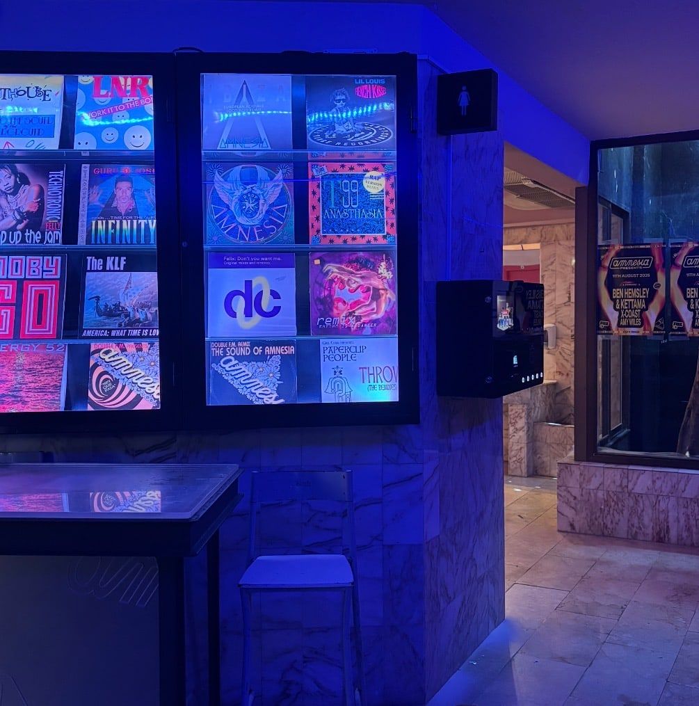 Perfume vending machine on the wall of a blue-lit club interior