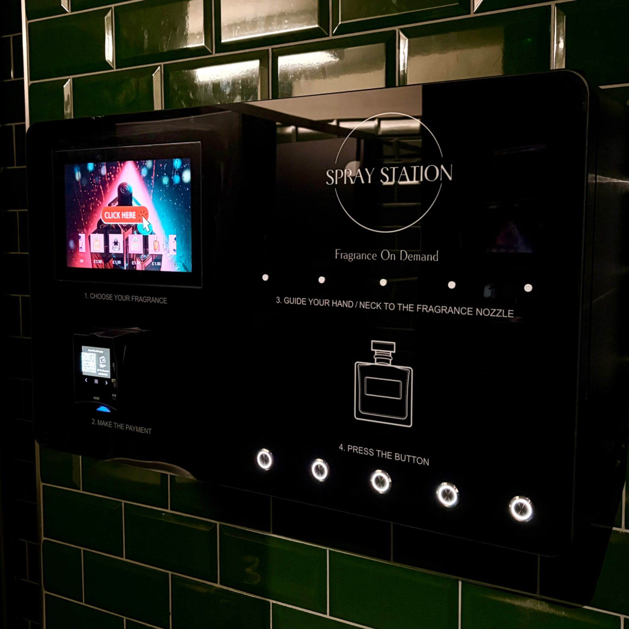 Spray Station perfume vending machine installed against green tiles in a venue washroom