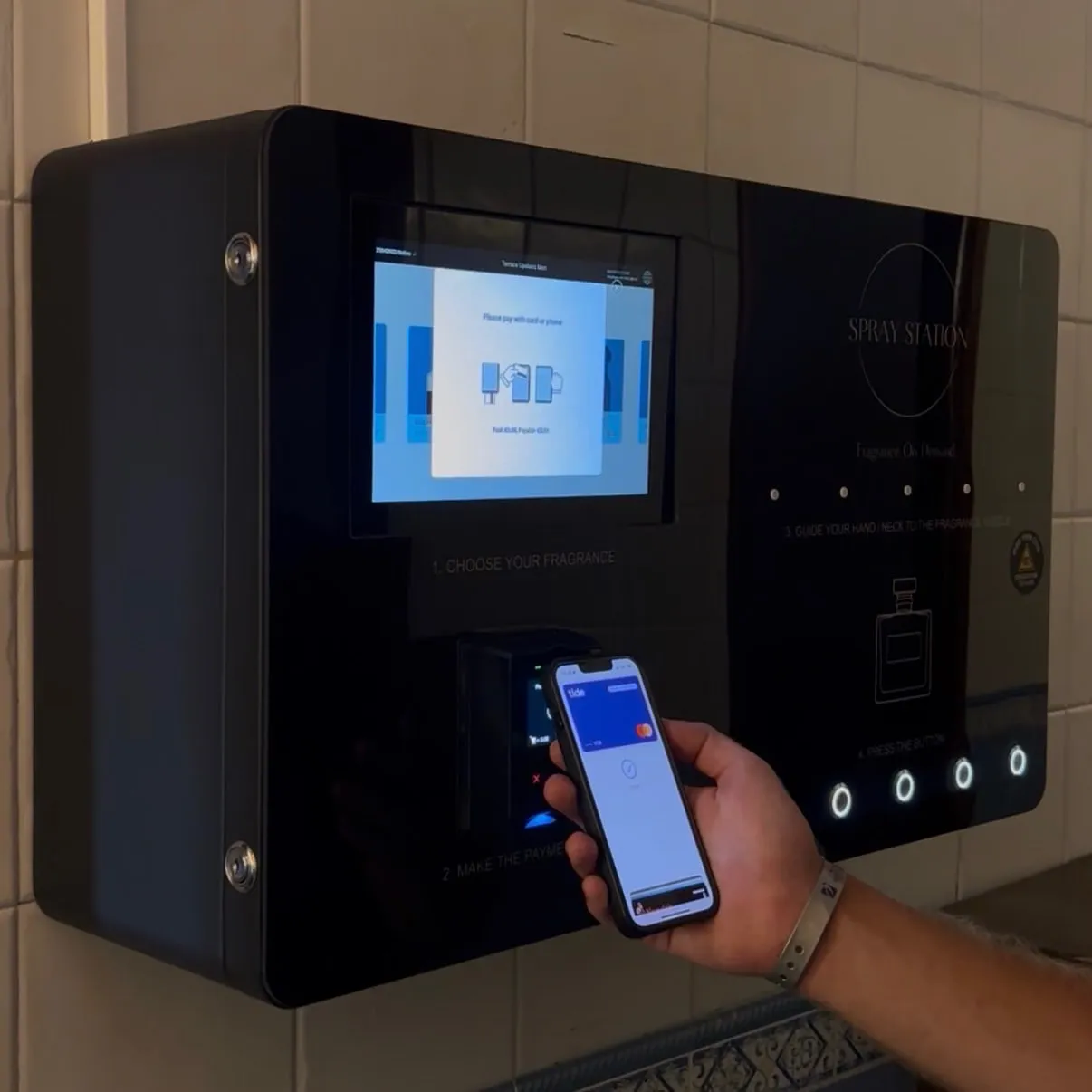 Customer paying on a Spray Box perfume vending machine with a phone